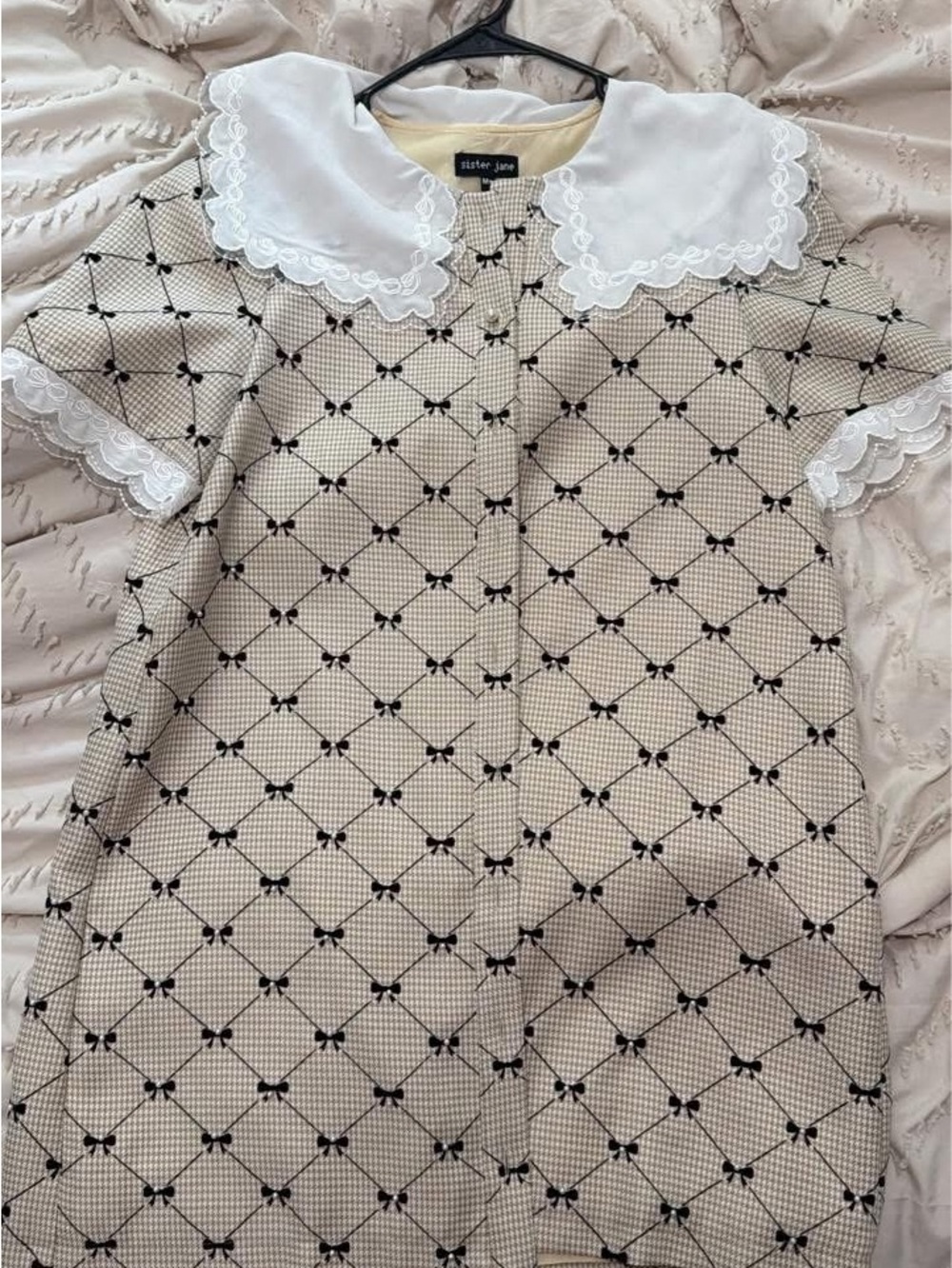 Sister Jane cream dress with black bow lattice and white scalloped collar